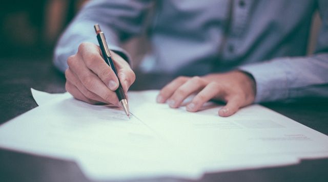 man signing papers